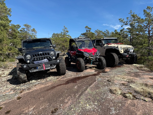 Three off-road vehicles on a wooded trail